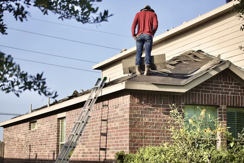 Professional roofer working on a residential roof in Forest Manor